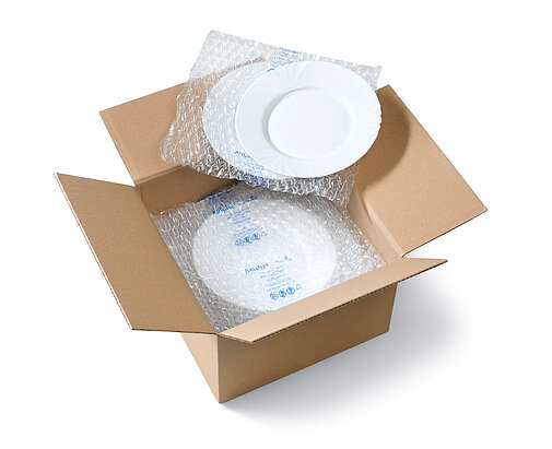 Una scatola di cartone contenente dei piatti e delle imbottiture d’aria