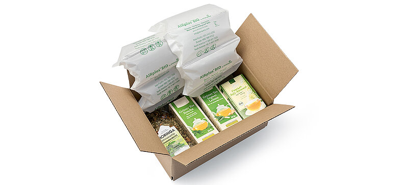 Una scatola di cartone con confezioni di tè e imbottiture d’aria biologiche