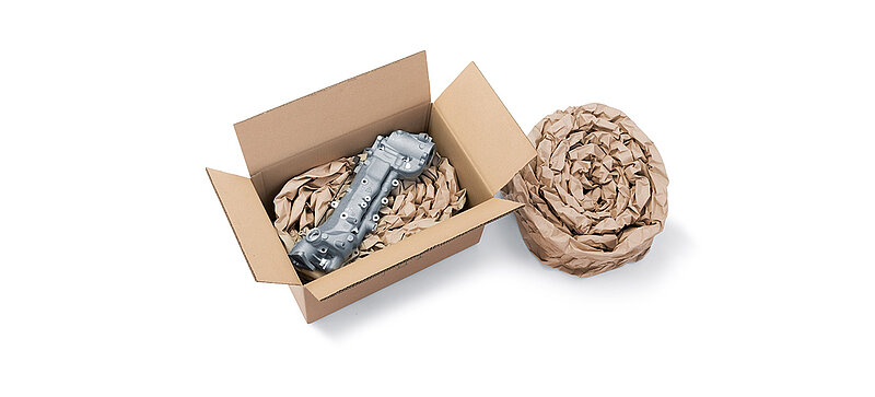 Una scatola di cartone contenente un componente e dell’imbottitura di carta prodotta da delle strisce d’imbottitura di carta arrotolate