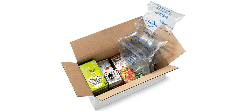 Una scatola di cartone con confezioni di tè e pluriball