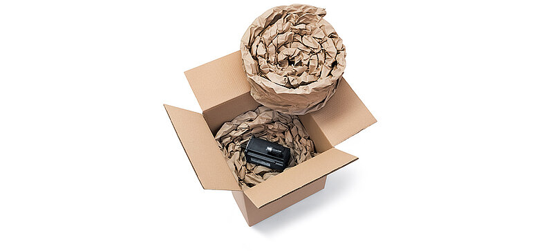Una scatola di cartone contenente un componente e dell’imbottitura di carta prodotta da delle strisce d’imbottitura di carta arrotolate