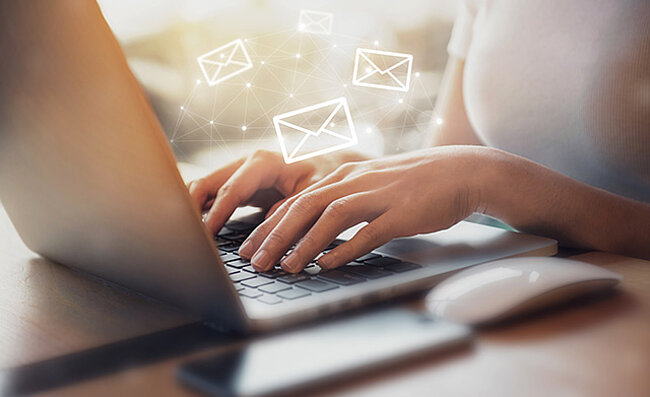 Hands typing on a laptop keyboard