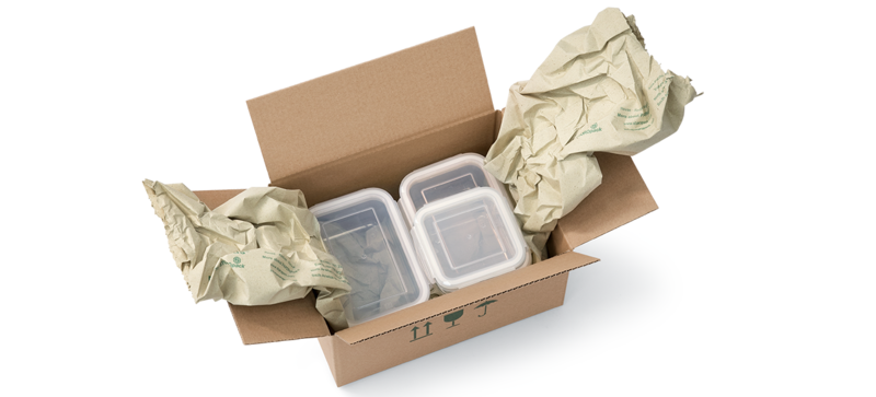 Una scatola di cartone contenente dei contenitori per alimenti e delle strisce d’imbottitura di carta prodotte con carta d’erba